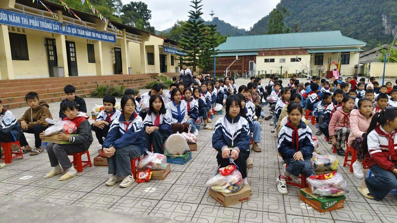 Các em học sinh nhận quà trên sân trường